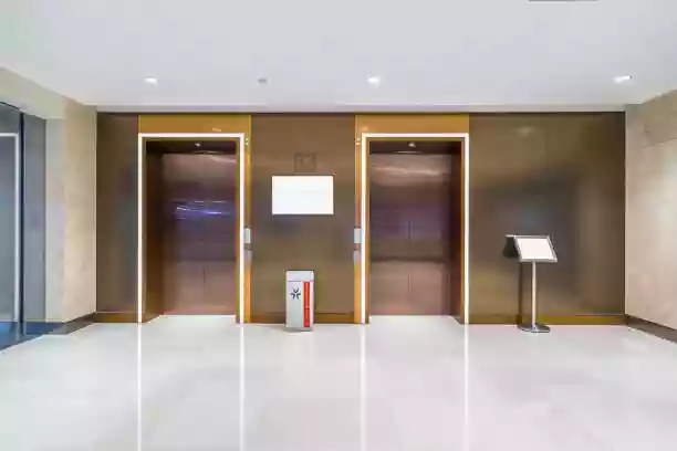 Modern traction elevator in a commercial office building lobby, designed for frequent use and energy efficiency.