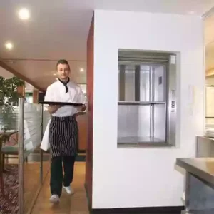Compact hydraulic elevator installed inside a small café, suitable for 2 to 4 floors.