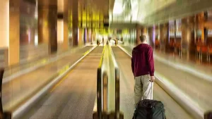 Men pulling suitcases on the moving sidewalks