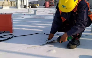 The picture shows workers laying waterproof membrane