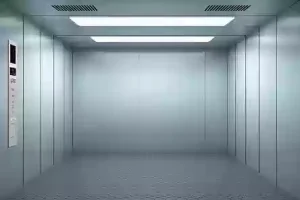 A real shot of the interior of a freight elevator, showing the exposed steel structure, large door opening, and no interior decoration